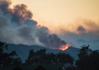 Smoke and flames of the Nuns Fire are seen one hill east of Oakville, seen from Napa, California.