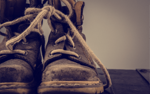 Close up of old construction boots on gray background